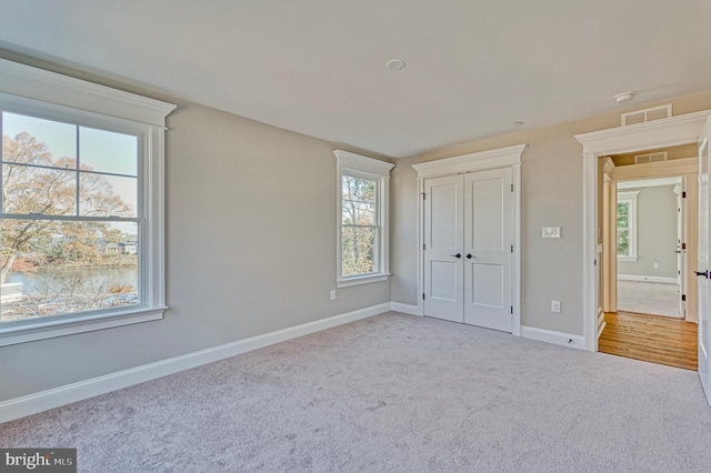 unfurnished bedroom featuring a closet, visible vents, carpet flooring, and baseboards