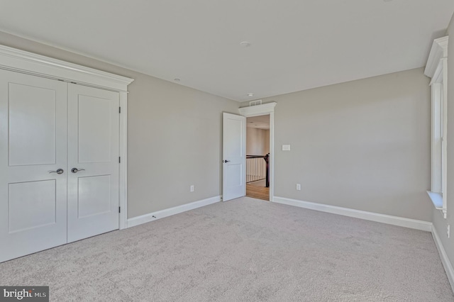 unfurnished bedroom with a closet, baseboards, and carpet