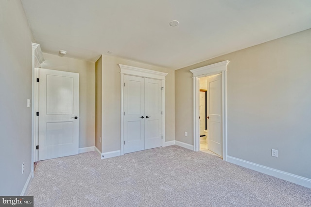 unfurnished bedroom with a closet, baseboards, and carpet floors