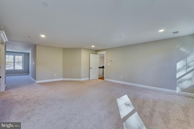 empty room featuring visible vents, carpet flooring, and baseboards