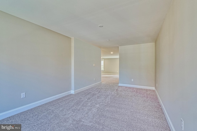 spare room with baseboards and carpet