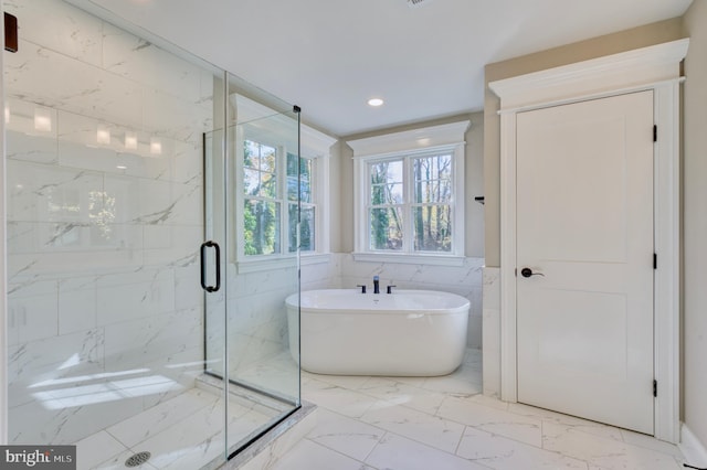 bathroom with marble finish floor, recessed lighting, a marble finish shower, tile walls, and a freestanding bath