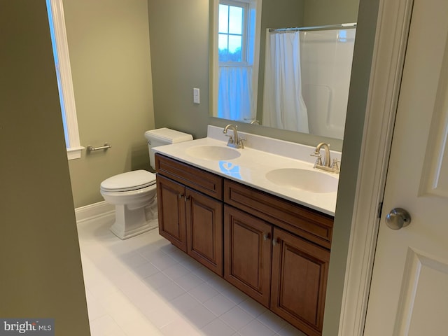 bathroom featuring toilet, dual vanity, and tile flooring