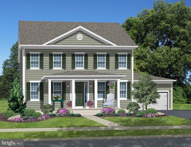 colonial home with covered porch, a front yard, and a garage