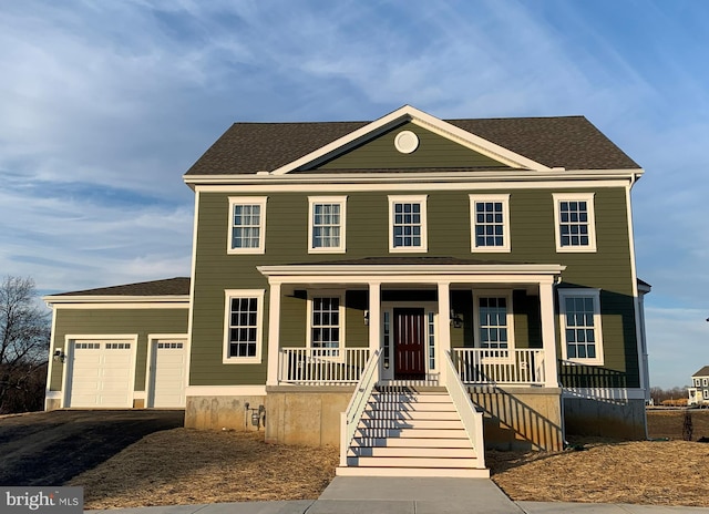 colonial inspired home featuring a porch and a garage