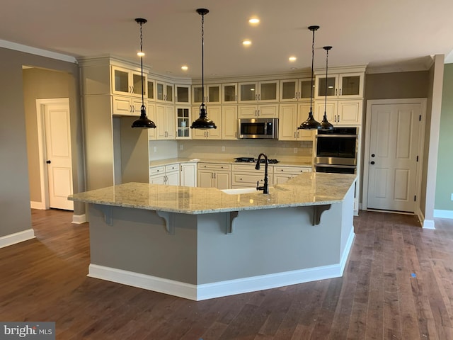 kitchen with dark hardwood / wood-style flooring, white cabinetry, a center island with sink, and decorative light fixtures