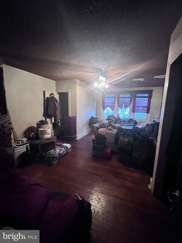 bedroom with ceiling fan, dark wood-type flooring, and a textured ceiling