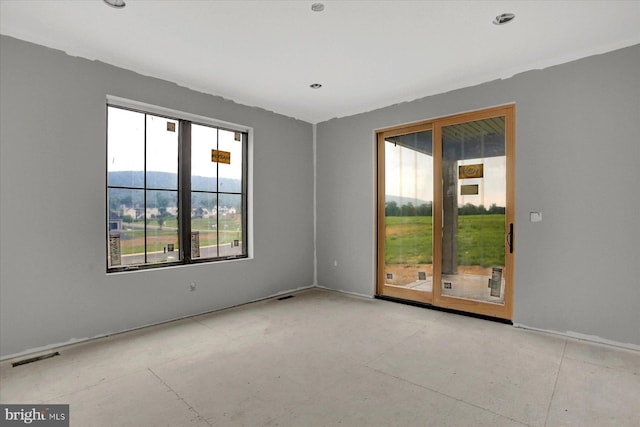 unfurnished room featuring a mountain view and a healthy amount of sunlight