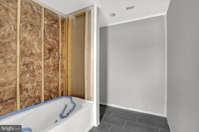 bathroom featuring tile patterned floors and a bath