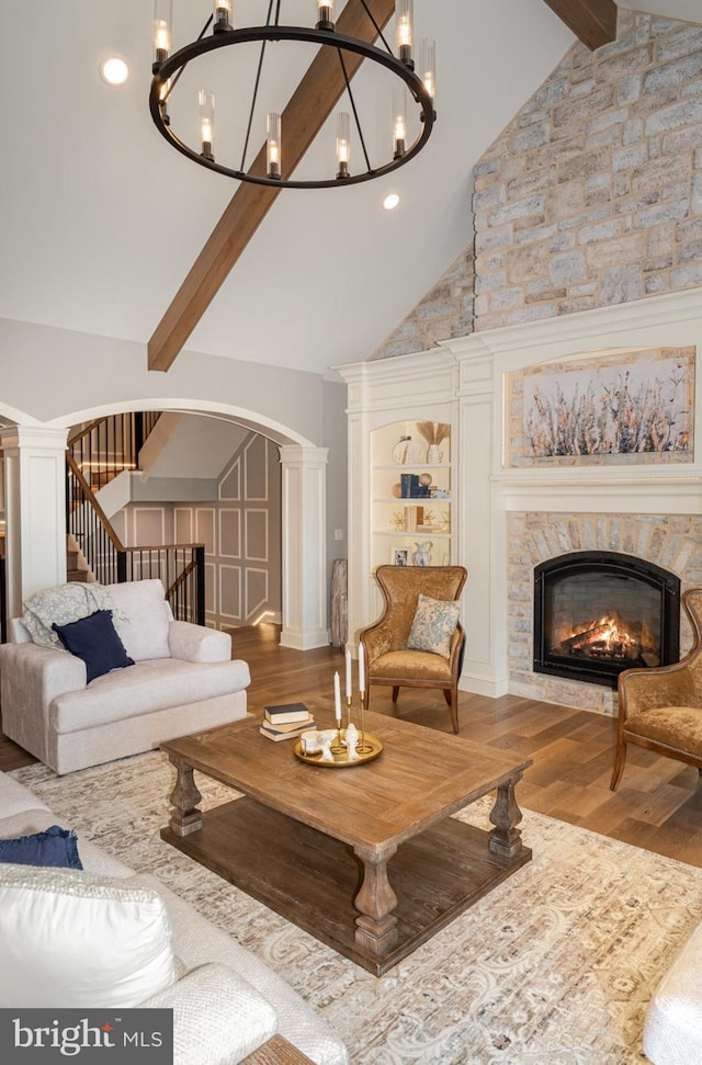 living room featuring high vaulted ceiling, built in features, a fireplace, beamed ceiling, and wood-type flooring