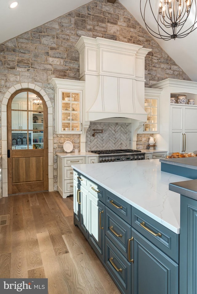 kitchen with blue cabinetry, backsplash, light hardwood / wood-style flooring, and white cabinets