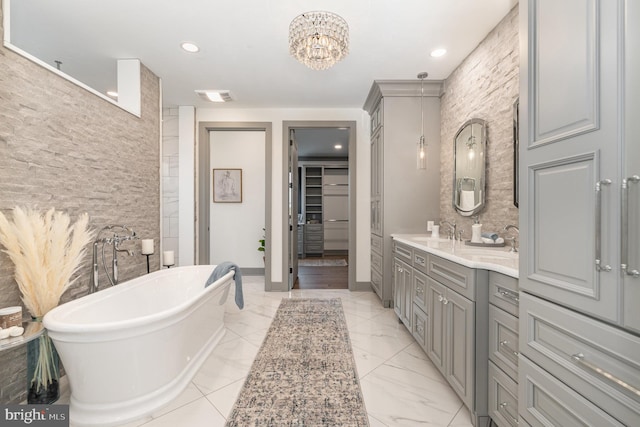 bathroom featuring vanity, a tub, and a notable chandelier