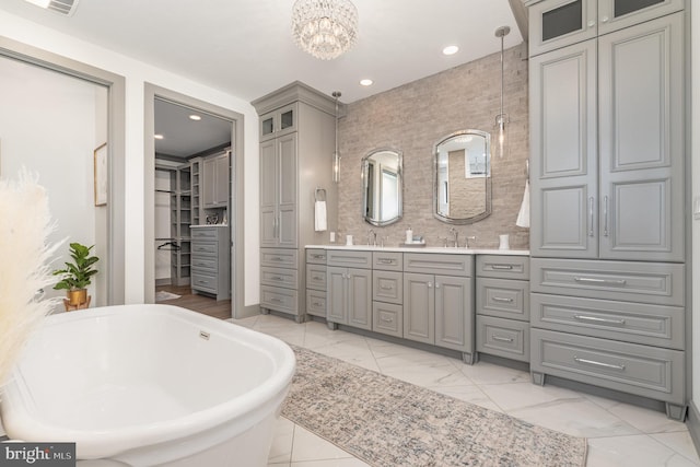 bathroom with a washtub, vanity, and a chandelier