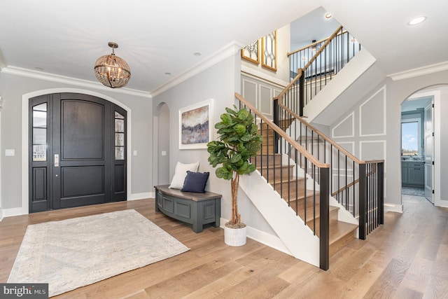 entryway featuring light hardwood / wood-style floors, an inviting chandelier, and crown molding