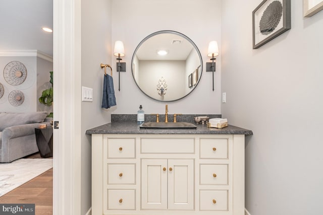 bathroom with vanity, hardwood / wood-style flooring, and crown molding