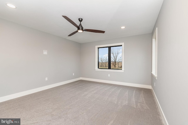 carpeted spare room with ceiling fan