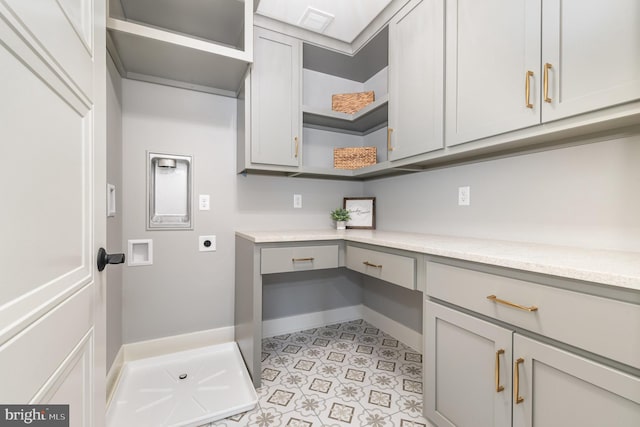 laundry room featuring electric dryer hookup and cabinets