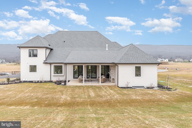 rear view of house featuring a patio area and a lawn