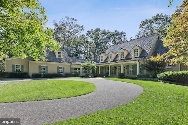 cape cod home with a front yard