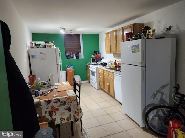 kitchen featuring white appliances, track lighting, light tile flooring, and sink