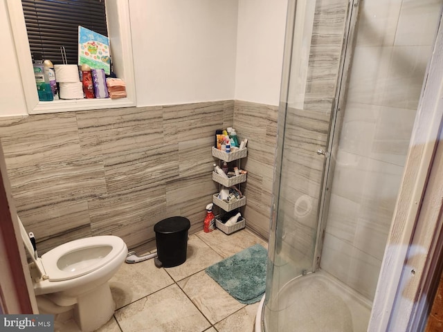 bathroom featuring tile flooring, tile walls, a shower with door, and toilet