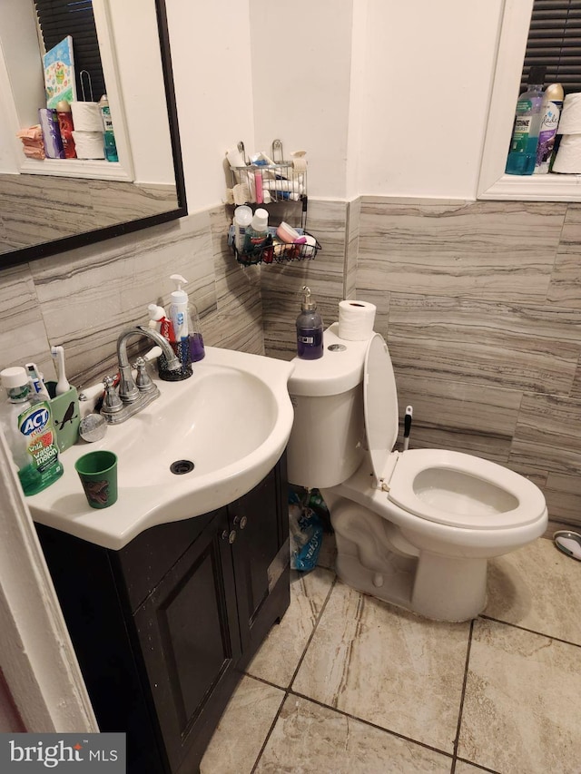 bathroom with toilet, tile flooring, and vanity