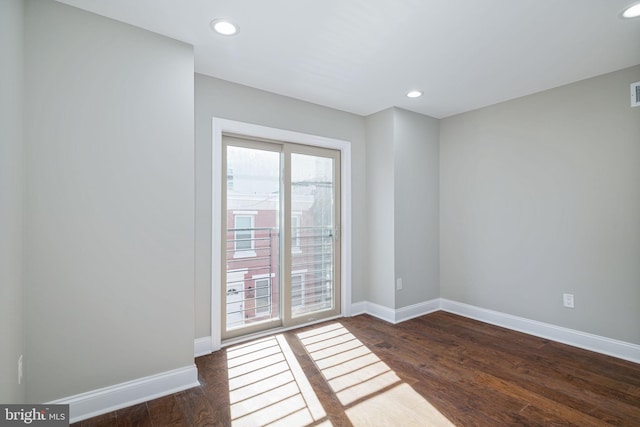 spare room featuring plenty of natural light and dark hardwood / wood-style floors