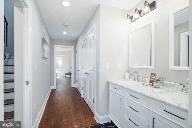 bathroom featuring double sink vanity and wood-type flooring