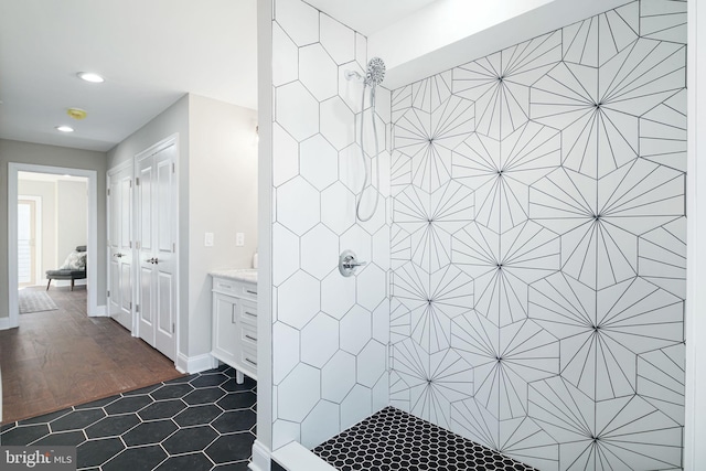 bathroom featuring tile floors, tiled shower, and vanity