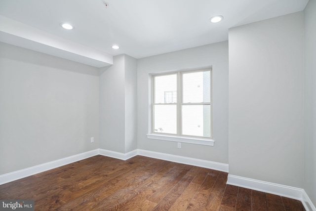 unfurnished room with dark wood-type flooring