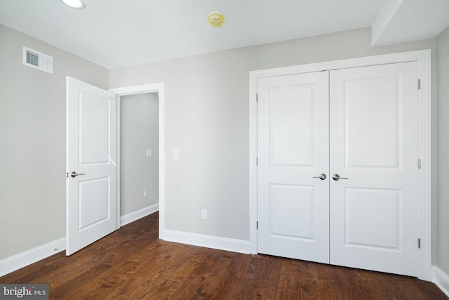 unfurnished bedroom with a closet and dark hardwood / wood-style floors