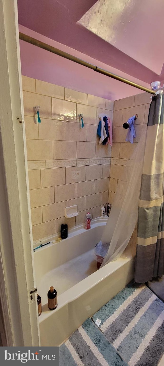 bathroom featuring shower / tub combo with curtain