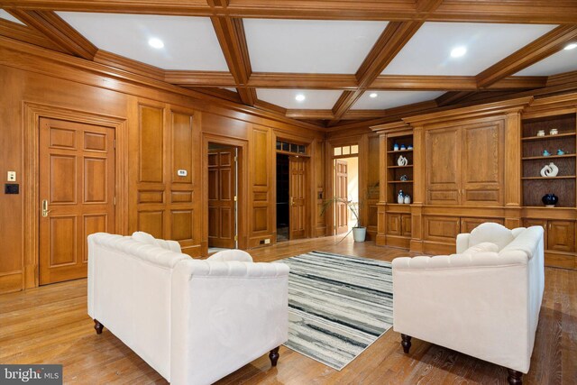 living room with light wood-type flooring, wooden walls, and coffered ceiling