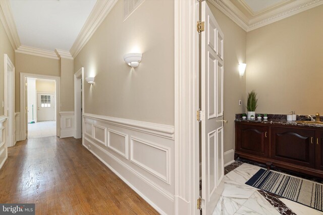 hall featuring crown molding, sink, and light wood-type flooring