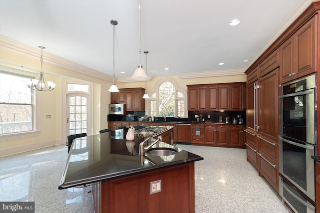 kitchen featuring a center island, stainless steel appliances, an inviting chandelier, crown molding, and pendant lighting