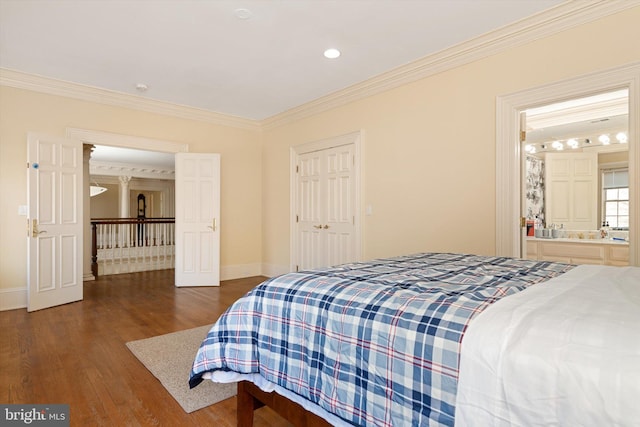 bedroom featuring dark hardwood / wood-style floors, ensuite bath, a closet, and crown molding