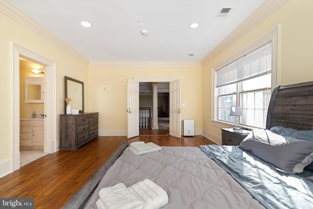 bedroom featuring dark hardwood / wood-style flooring, crown molding, and connected bathroom