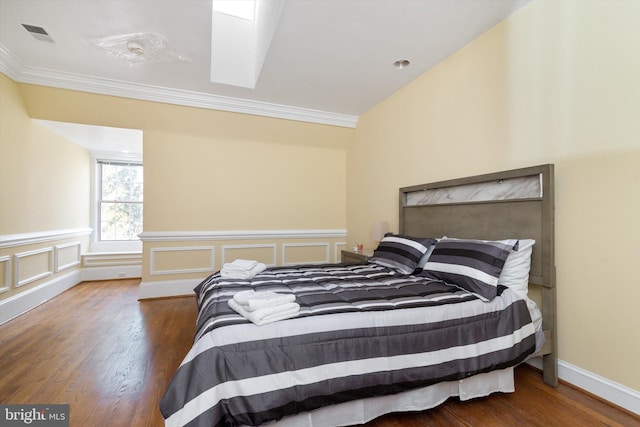 bedroom featuring hardwood / wood-style floors, vaulted ceiling, and ornamental molding