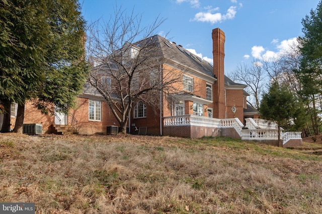 rear view of house with cooling unit and a deck