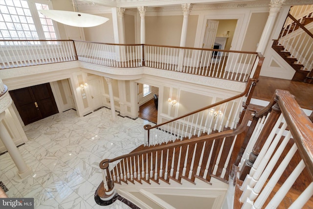 stairs featuring ornate columns and a towering ceiling