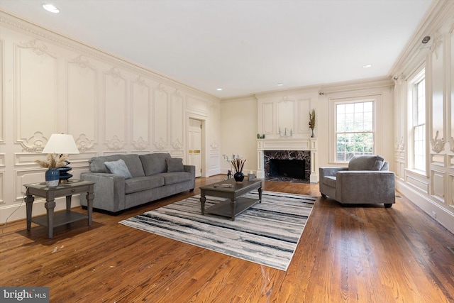 living room with a premium fireplace, crown molding, and dark wood-type flooring