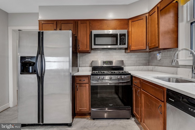 kitchen with light stone counters, light tile floors, appliances with stainless steel finishes, and sink