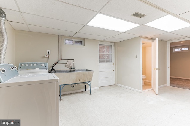 laundry area featuring washing machine and dryer and light tile floors