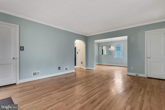 empty room featuring crown molding, a chandelier, and light hardwood / wood-style floors