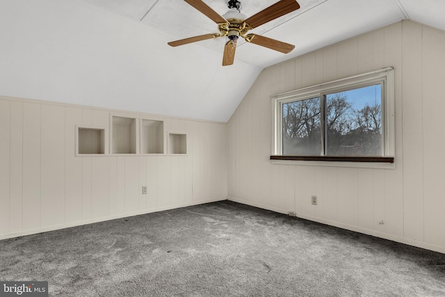 additional living space with ceiling fan, dark colored carpet, and lofted ceiling