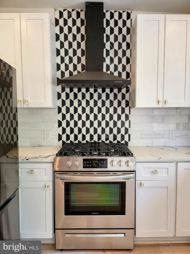 kitchen with white cabinets, backsplash, appliances with stainless steel finishes, and light stone countertops