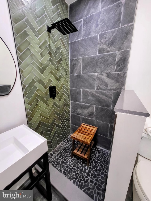 bathroom with tiled shower and toilet