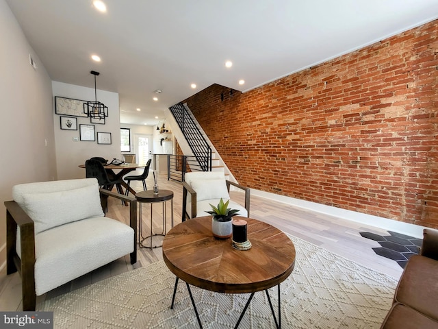 sitting room with brick wall and light wood-type flooring