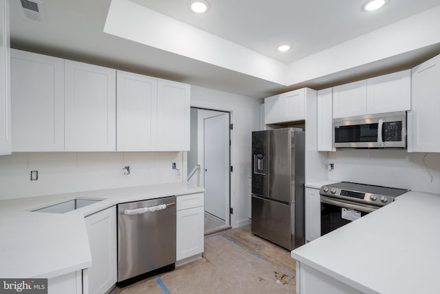 kitchen with white cabinets, appliances with stainless steel finishes, and light wood-type flooring