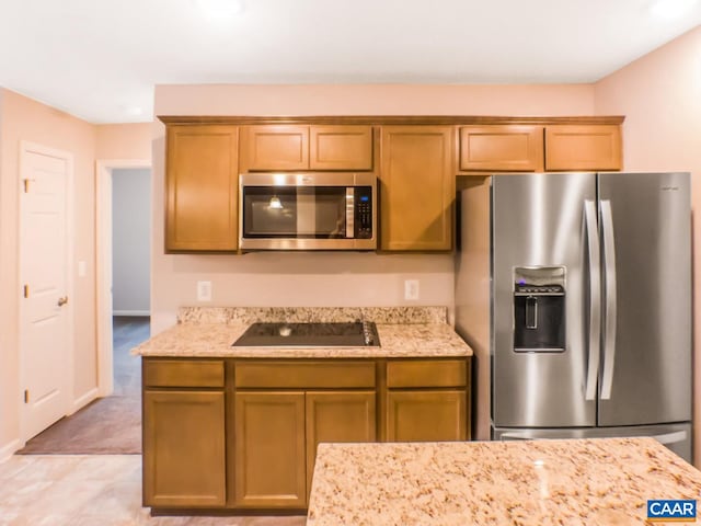 kitchen featuring light carpet, appliances with stainless steel finishes, and light stone counters